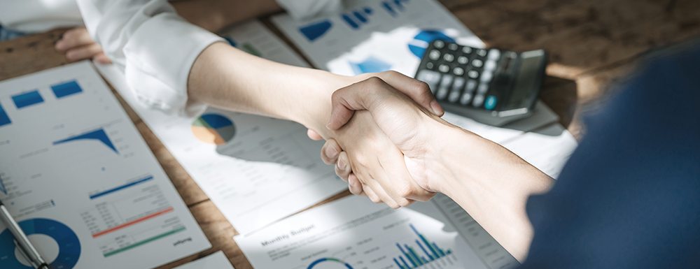 Two people shaking hands. (How to Start or Buy a Business or Franchise - Guidant Blog).