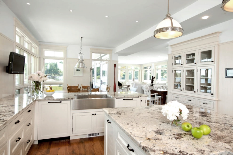 White marble countertops in a kitchen with an island - Installed by Granite and Marble Solutions.