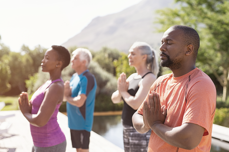 A group of older adults gather and pose for a meditation session together - Mental health and wellness services are on the rise, making for a recession proof industry. 