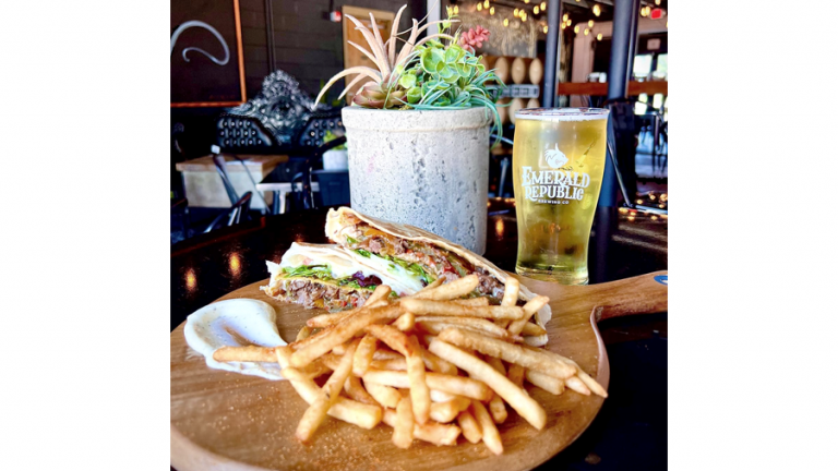 A classic wrap and truffle fries dish from A Rustyc Spoon served with a cold glass of beer.