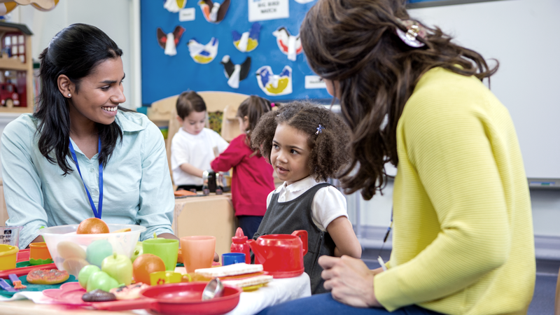 Childcare is here to stay: Top childcare franchises are rising for a reason. Image shows childcare workers taking care of children while smiling. 