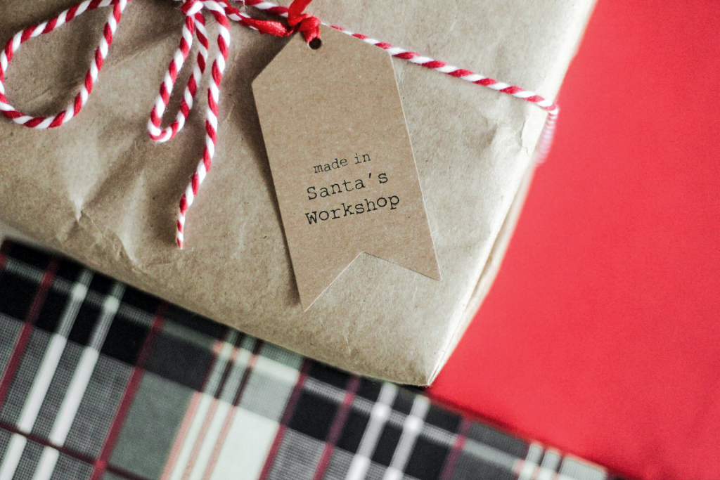 Gifts wrapped in red and plaid with ribbons and a tag that reads "Made in Santa's Workshop." Personalizing and making your products special can help increase holiday sales.