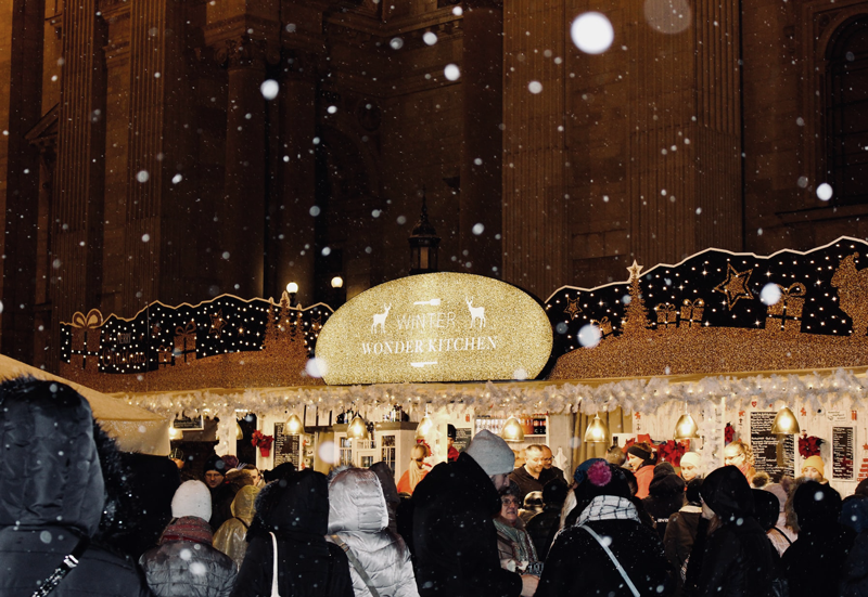 Seasonally decorated restaurant storefront that reads "Winter Wonder Kitchen" with bright lights. Decorating can help increase holiday sales. 