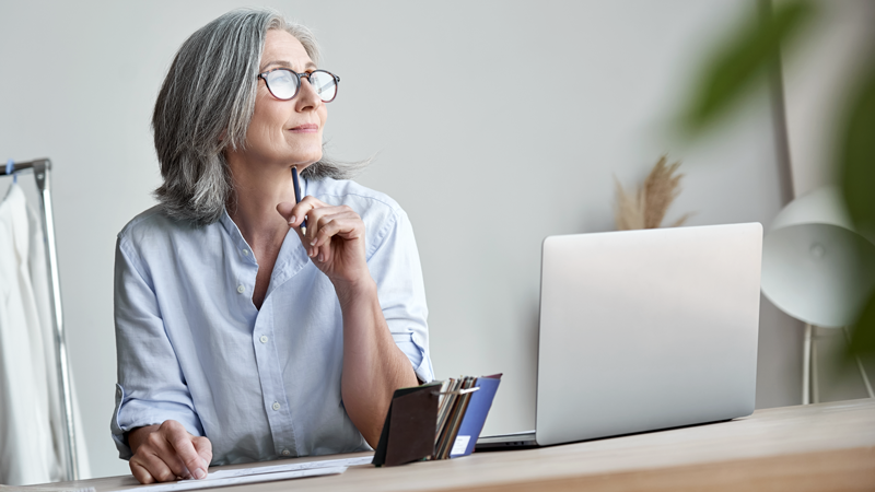 Woman looking reflectively while at her desk. (Using Your 401(k) as an SBA loan down payment - Guidant Blog.)