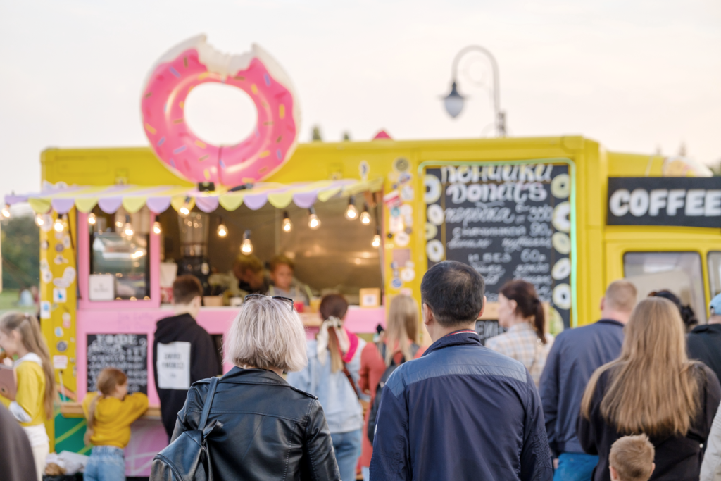Food truck with a doughnut on top and people crowding around it. (How to Build a Brand and Measure OKRs Blog.)