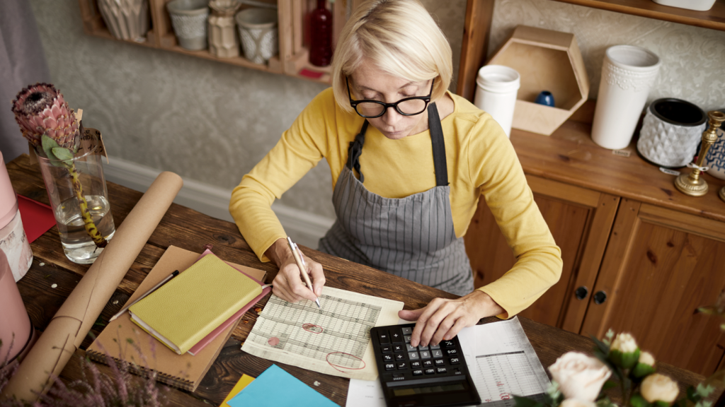 Business owner filing her taxes at a table. (10 Tax Benefits of C Corporations - Guidant Blog.)