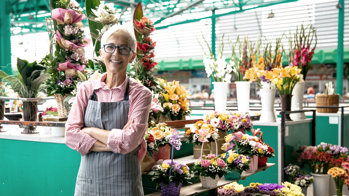 Business owner standing in front of a selection of flowers (Ways to Celebrate Small Business Week - Guidant Blog)