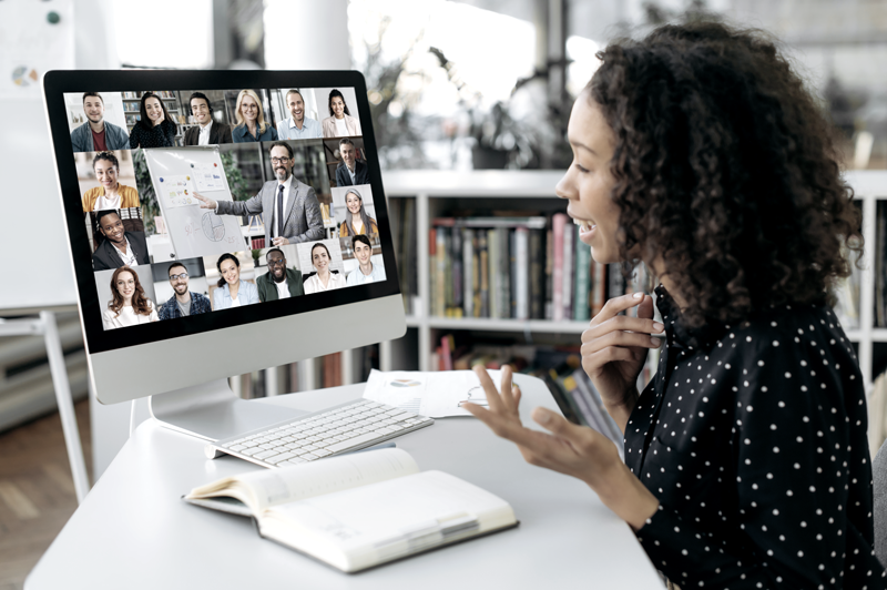 Woman at desk joining a virtual company meeting on her desktop computer and participating in discussion. (Top Remote Work Tips for Staying Connected and Efficient — Guidant Blog.)