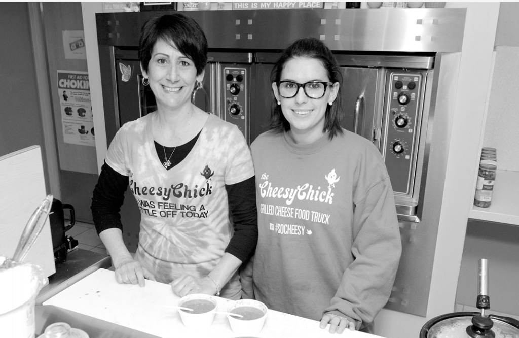 Photo of Simone Fancher, owner of the Cheesy Chick, working in the kitchen. (Inspiring Small Businesses to Celebrate - Guidant Blog.)