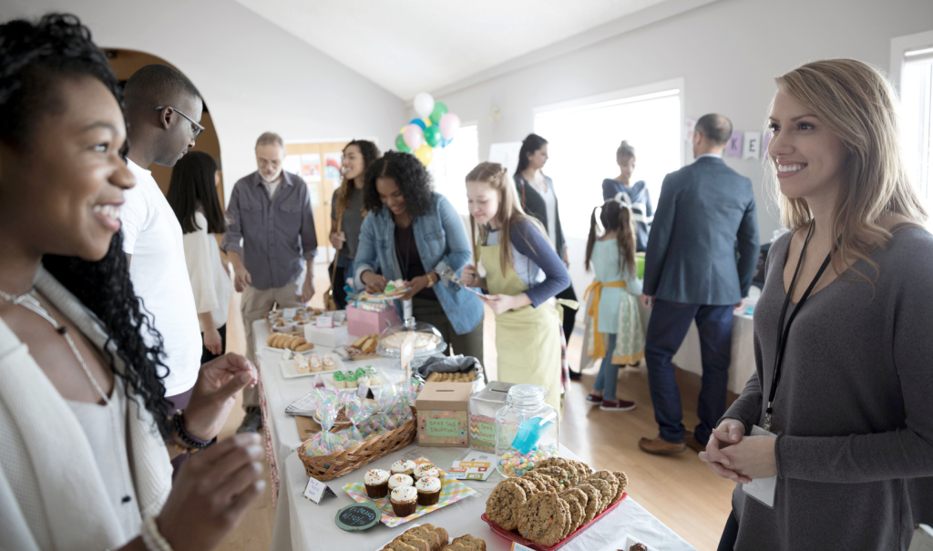Fundraising baking event with a diverse group of people ranging in age. (Ways to Celebrate Juneteenth for Small Businesses - Guidant Blog). 