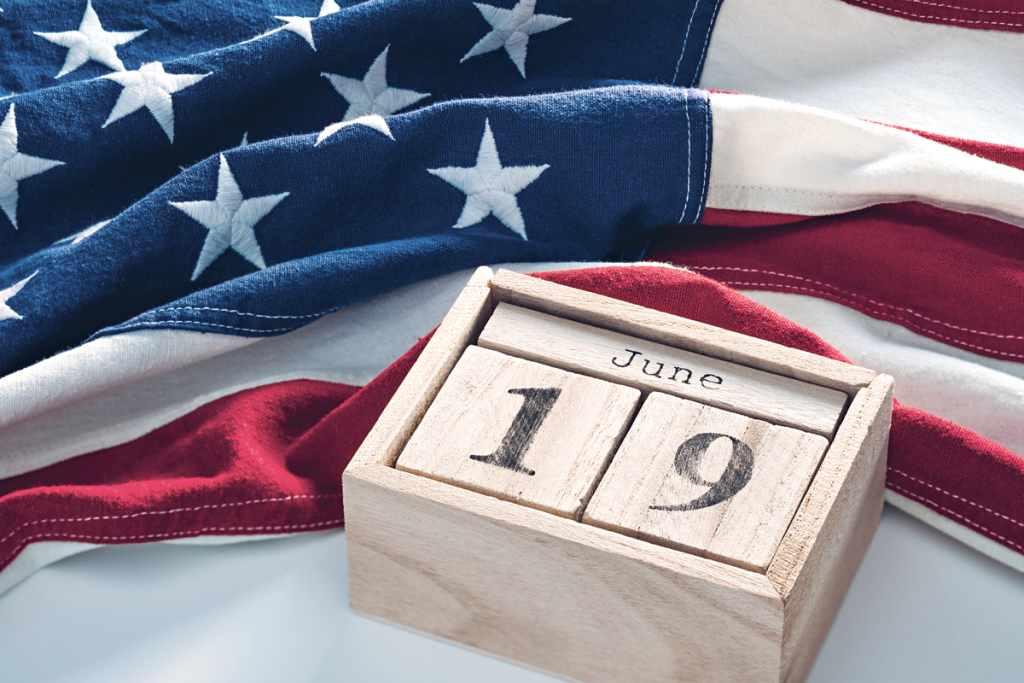 American flag with "June" and "19" wooden blocks on top of it. (Ways to Celebrate Juneteenth for Small Businesses - Guidant Blog.) 