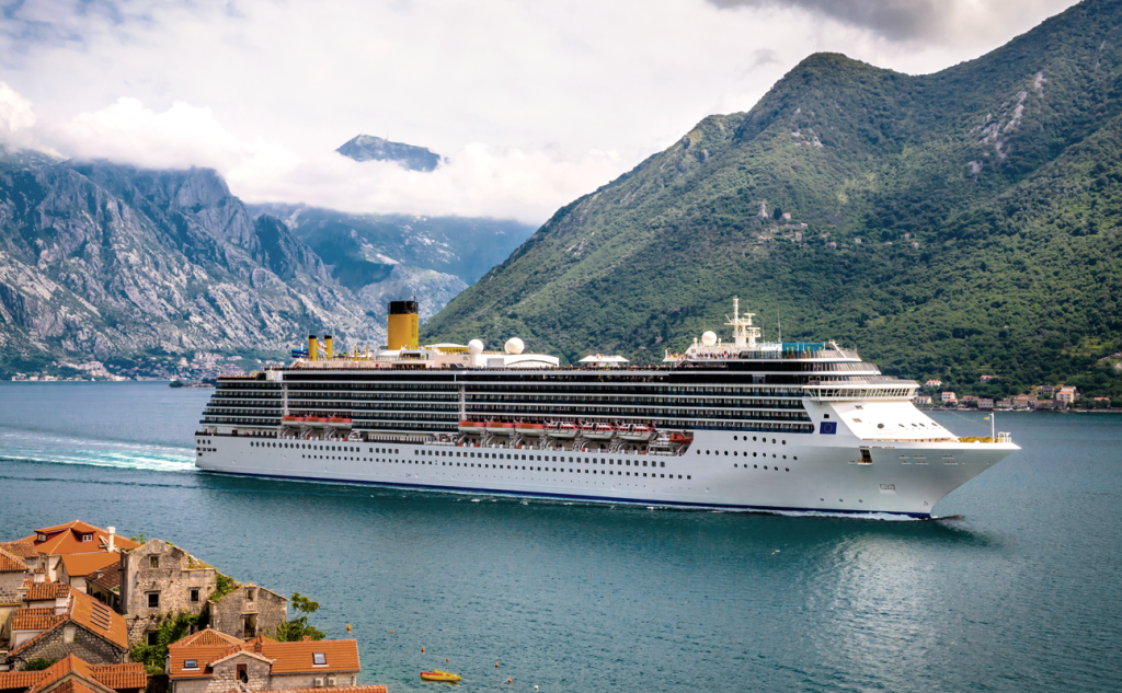 Cruise ship on the sea next to mountains. (Top 10 Summer Franchises - Guidant). 