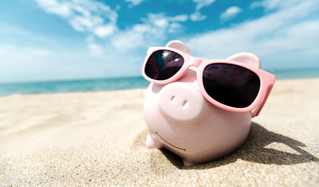 Piggy bank on a beach wearing sunglasses. (Turn Up the Heat with these Top 7 Summer Sale Promotion Ideas for Small Businesses - Guidant Blog.)