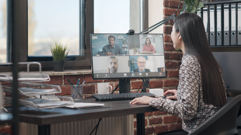 Woman sitting at desk on a video call smiling.  (Top 5 Surprising Benefits of Offshoring for Small Businesses - Guidant)