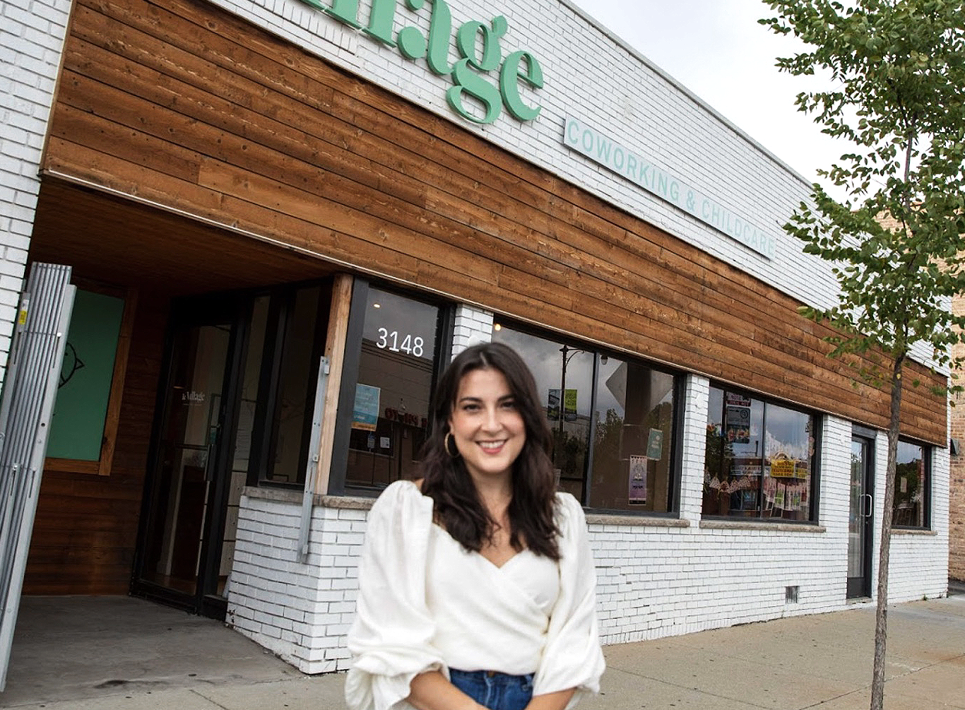 Daniella Cornue, Hispanic business owner of Le Village Cowork, standing outside of her business. (Top Resources and Grants for Hispanic Entrepreneurs - Guidant Financial Blog).