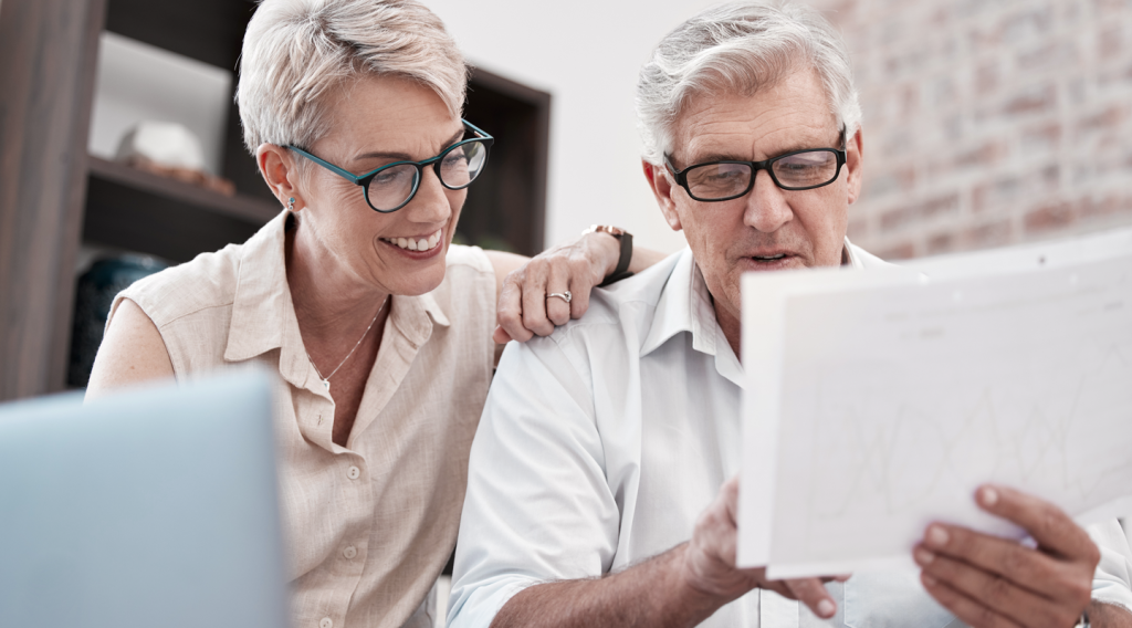 Older business owner couple smiling and reviewing documents together. (What is ROBS? How 401k Business Financing Works - Guidant Blog).