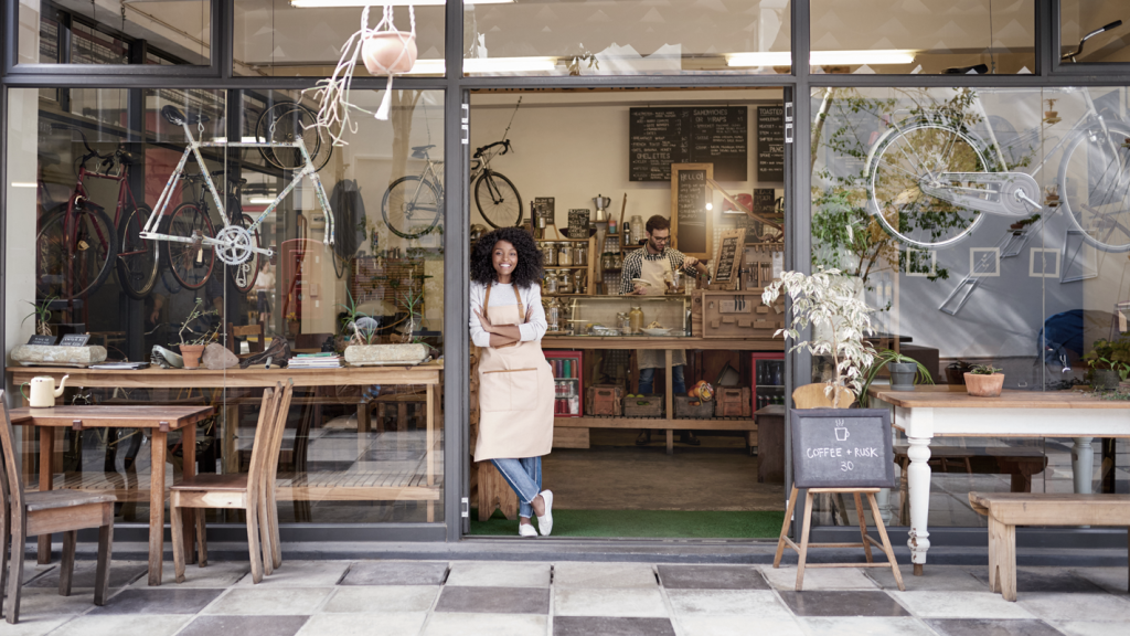 Business owner smiling outside of bicycle storefront. (Navigating the New Banking Landscape as a Small Business - Guidant Blog).