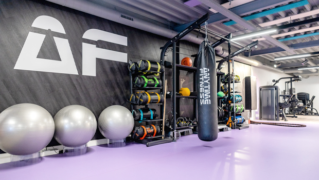 An Anytime Fitness workout room equipped with punching bags and a variety of exercise equipment. (Hottest Fitness Franchises of 2023-2024 - Guidant Blog).