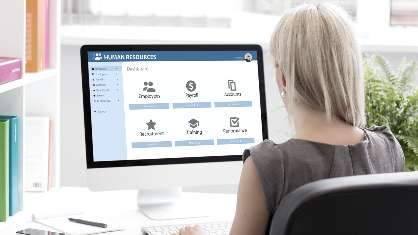 Woman at desk using software for Payroll and Human Resources. (Complete Guide to Payroll for Small Businesses - Guidant Financial.)