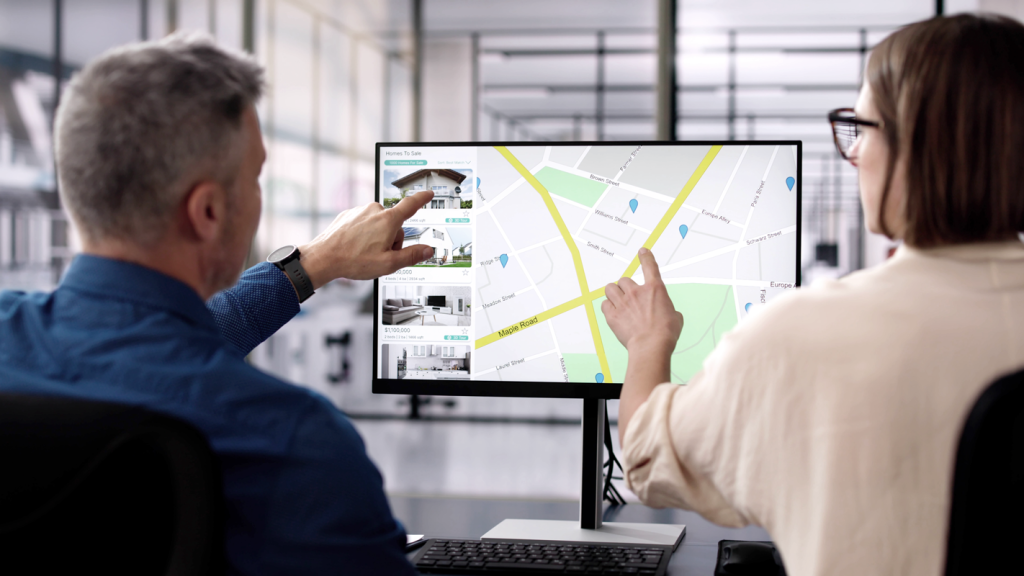 Man and woman selecting location on computer screen. (Selecting the Perfect Small Business Location - Guidant Blog).