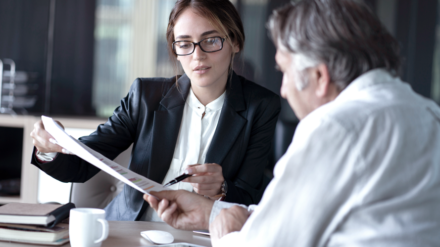 Woman showing man a document. (7 Common Funding Small Business Mistakes - Guidant blog)