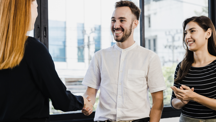 Two people shaking hands and another person clapping. (7 Common Funding Small Business Mistakes - Guidant blog)