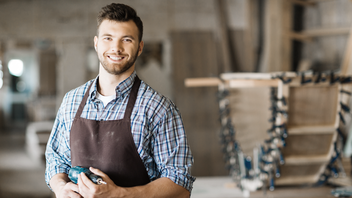 Man in apron against construction setting. (Taking the Leap: 7 Tips for Aspiring Entrepreneurs - Guidant Blog)